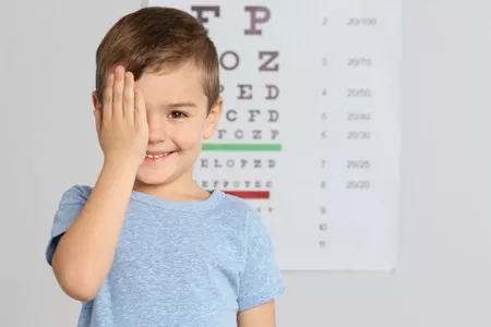 little boy in front of an eye chart