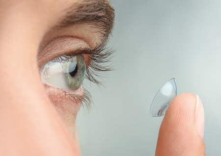 Man with contact lens on his finger